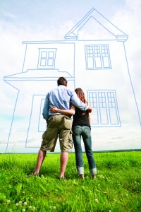 Mężczyzna i kobieta stojący na działce, gdzie stanie dom.